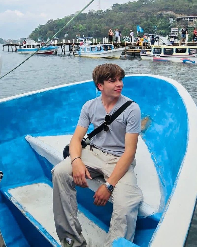 Daniel Aleks sentado en un bote en un lago